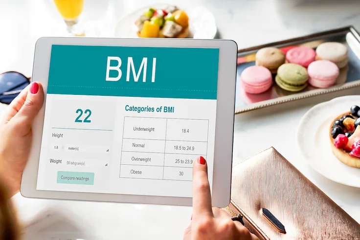 Person checking BMI calculator on tablet for health and weight management