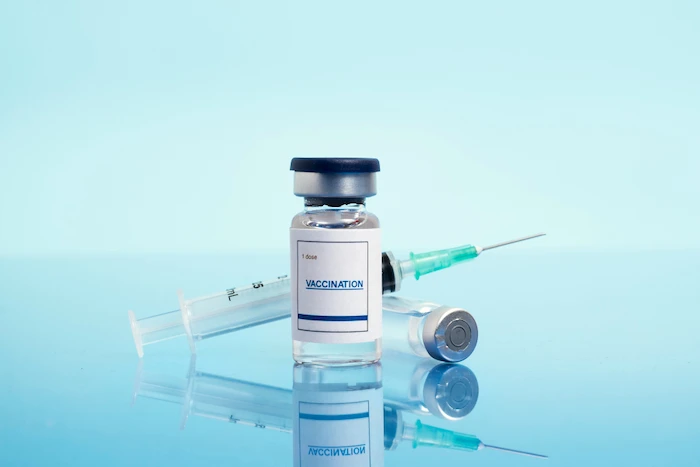 Vaccine vial and syringe for vaccination on blue medical background